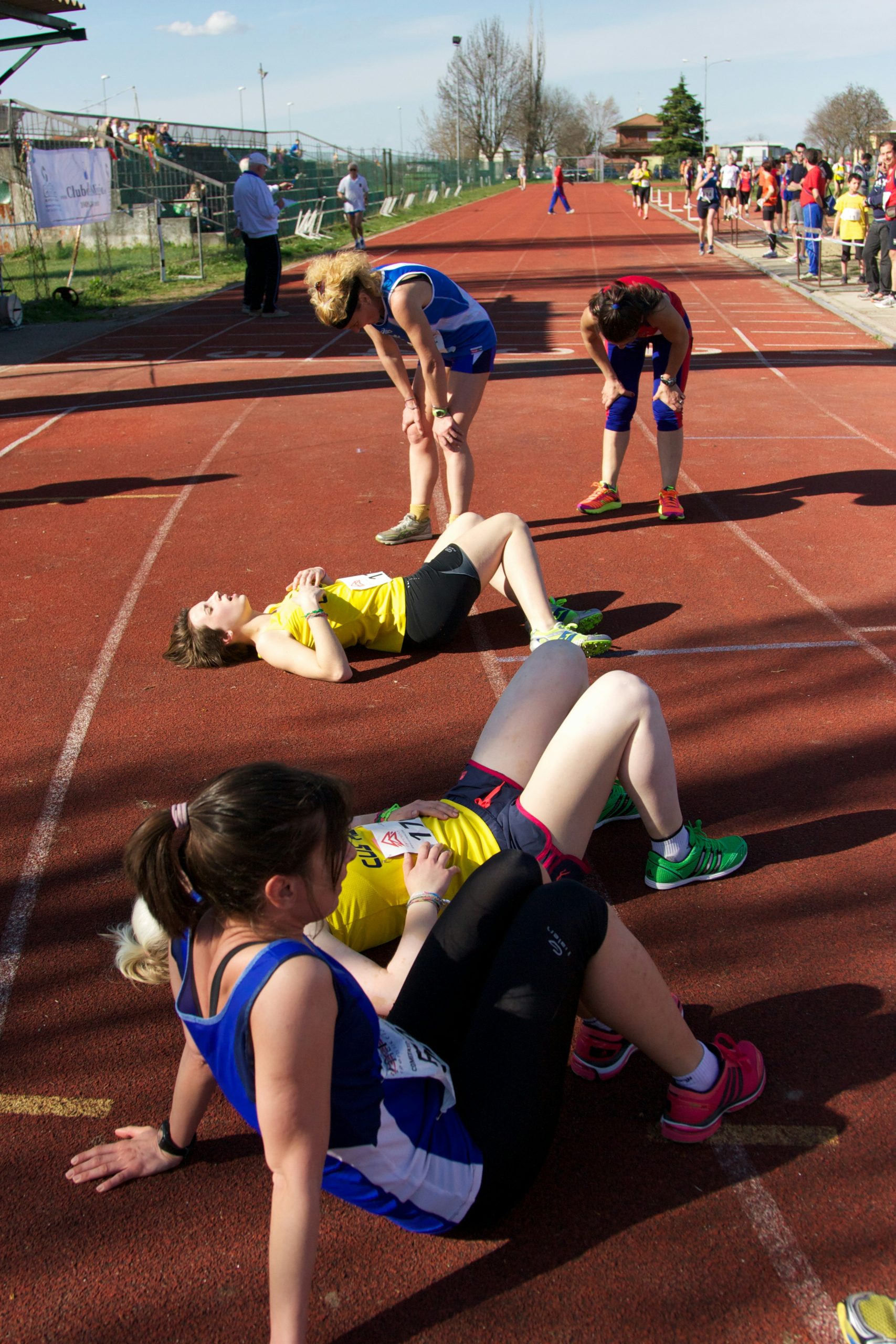 Athletes at the end of a race. Some are lying on the floor.